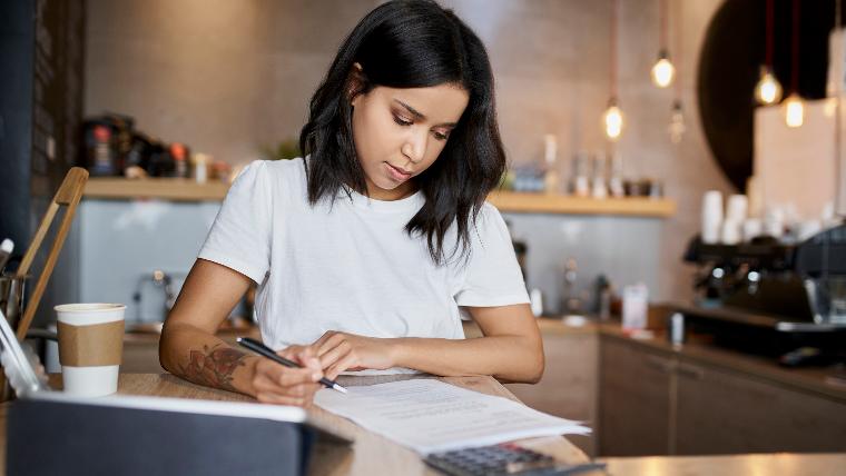 Woman calculating credit utilization.