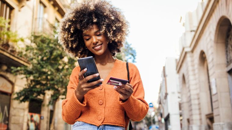 Young woman making a purchase on her phone.