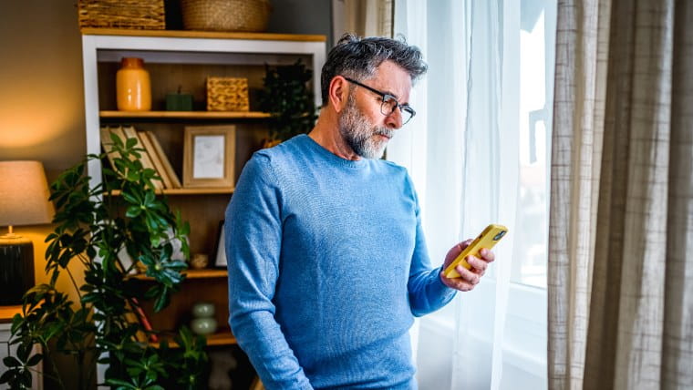 Concerned man reading cellphone.