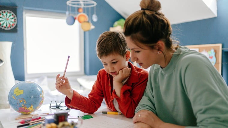 Mother homeschooling small child.