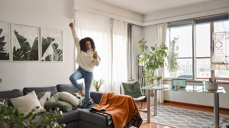 Young woman dancing on couch.