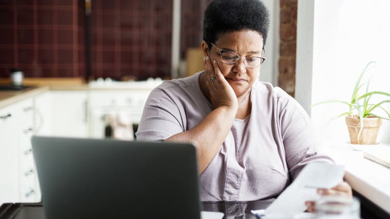 Unhappy woman reading billing statement.