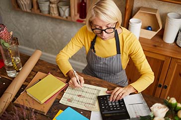 Older caucasian woman working on balance sheet