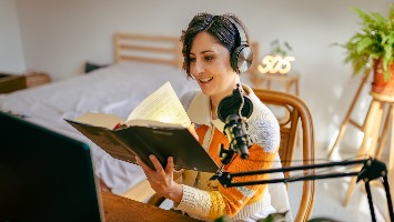Woman recording herself narrating a audiobook.