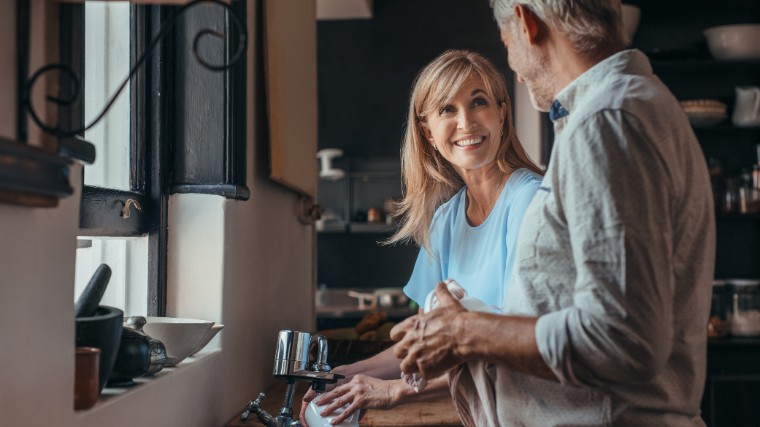 Mature couple having conversation in the kitchen.